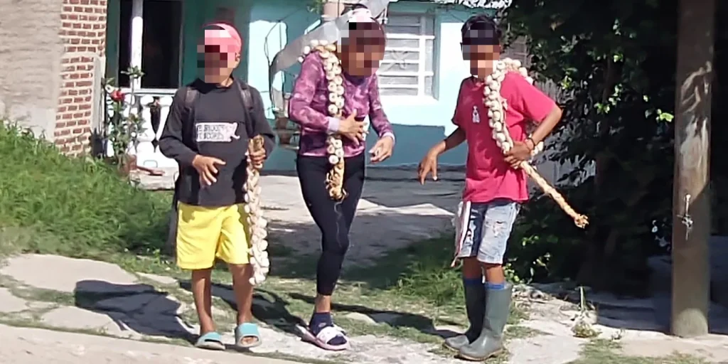 Dos niños con una mujer adulta. Los tres venden ajos (Foto: CubaNet)